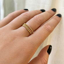 14k gold bead rings stacked together on a hand