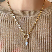 chunky paperclip chain necklace with round pave face charm lock and blue lace agate drop charm on a neutral knit sweater.