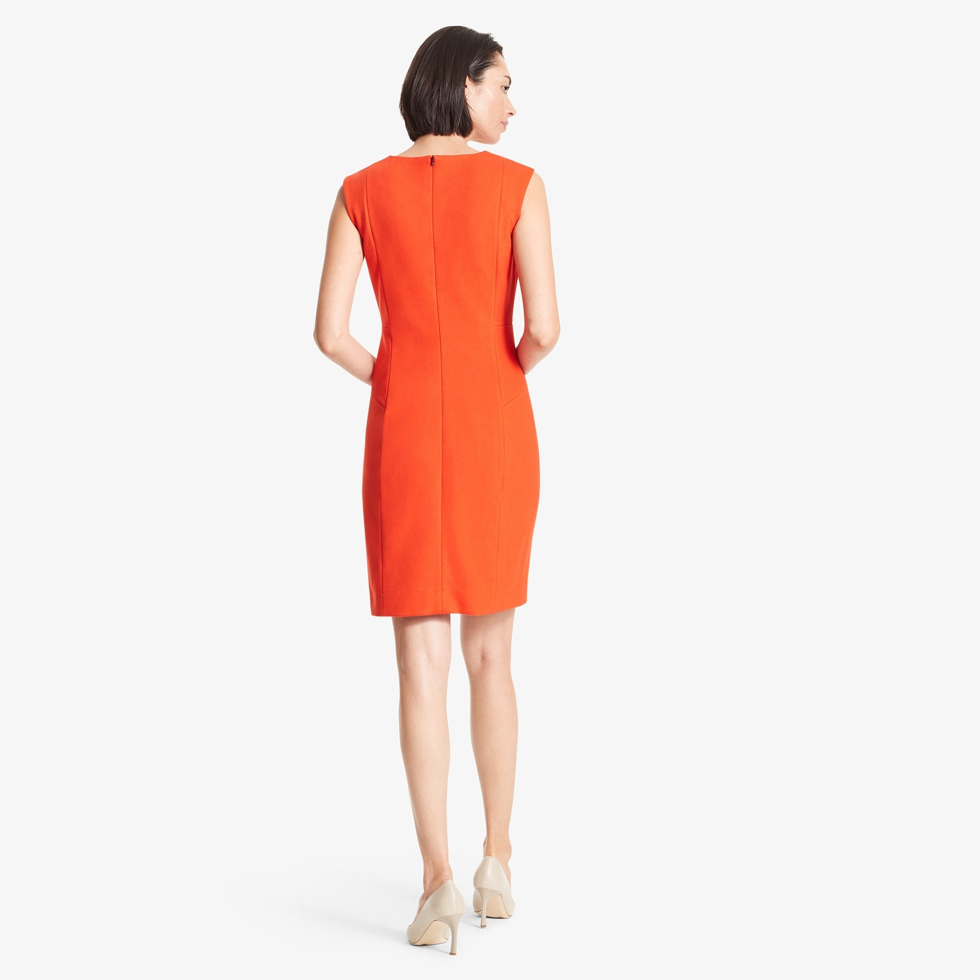 Back image of a woman standing wearing the Giovanna dress in Tangerine | Exclude