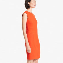 Side image of a woman standing wearing the Giovanna dress in Tangerine | Exclude