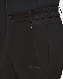 Close-up of Rudsak KICO - 6523508 Black tailored men’s outdoor pants with an elastic waistband, zippered side pocket, and subtle branding by the pocket, paired with a matching dark top.