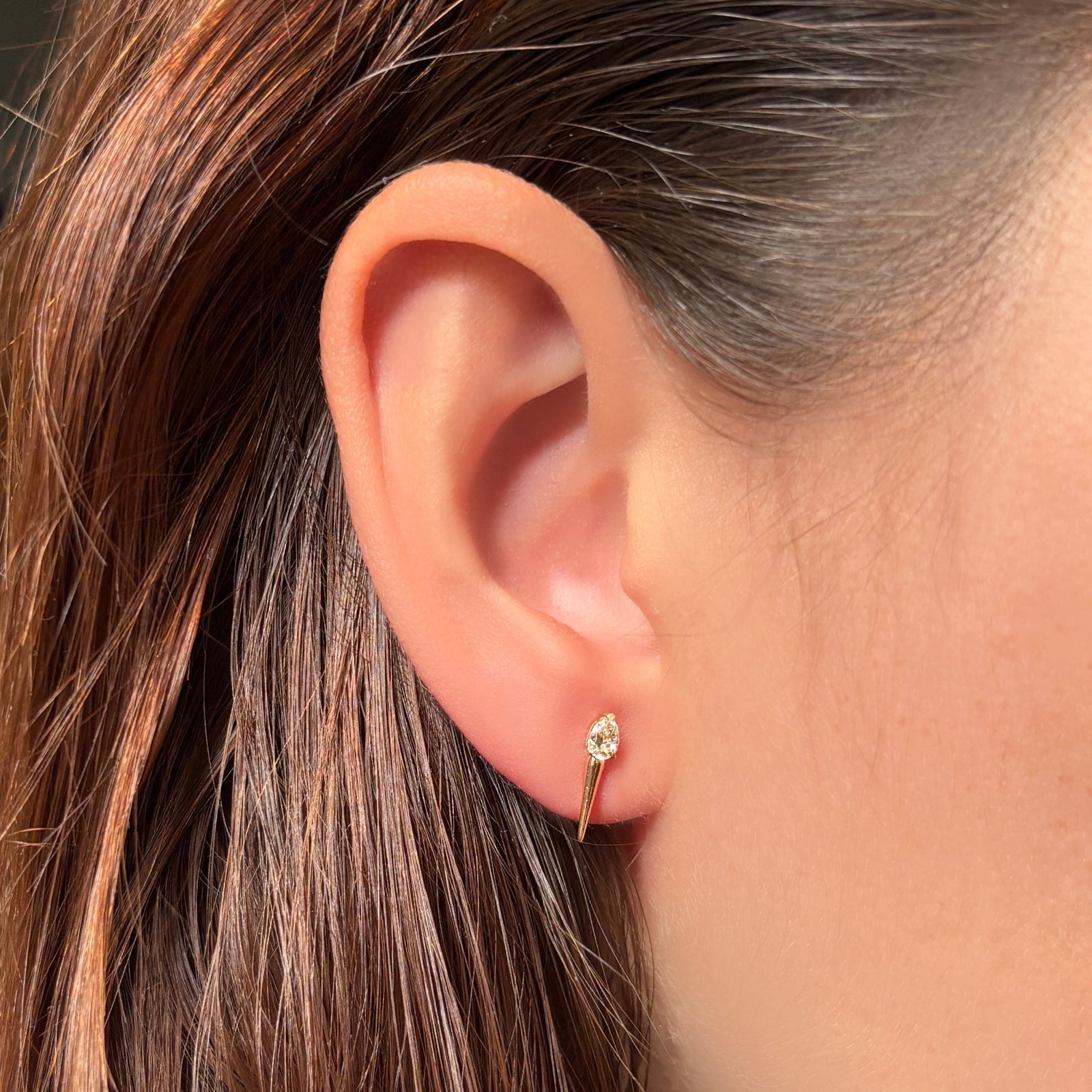Elements Diamond Spike Stud featuring a pear shaped diamond in 14k yellow gold on the ear.