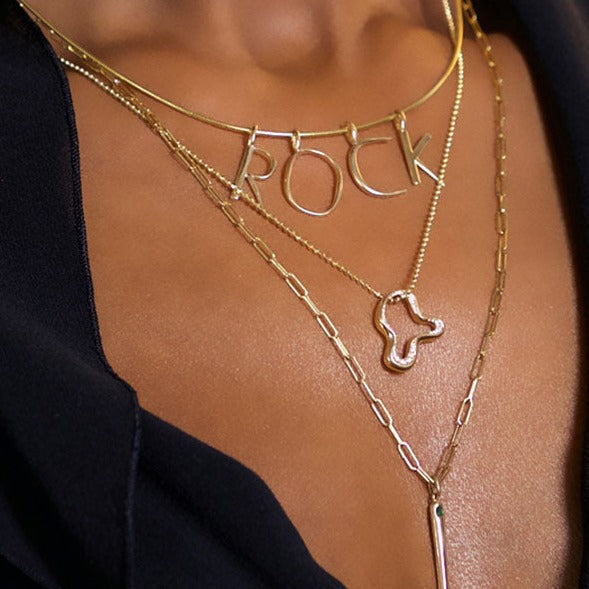 14k recycled gold Demi Pavé Ripple Charm. Hanging from a diamond cut bead necklace layered with the wire choker and letter charms